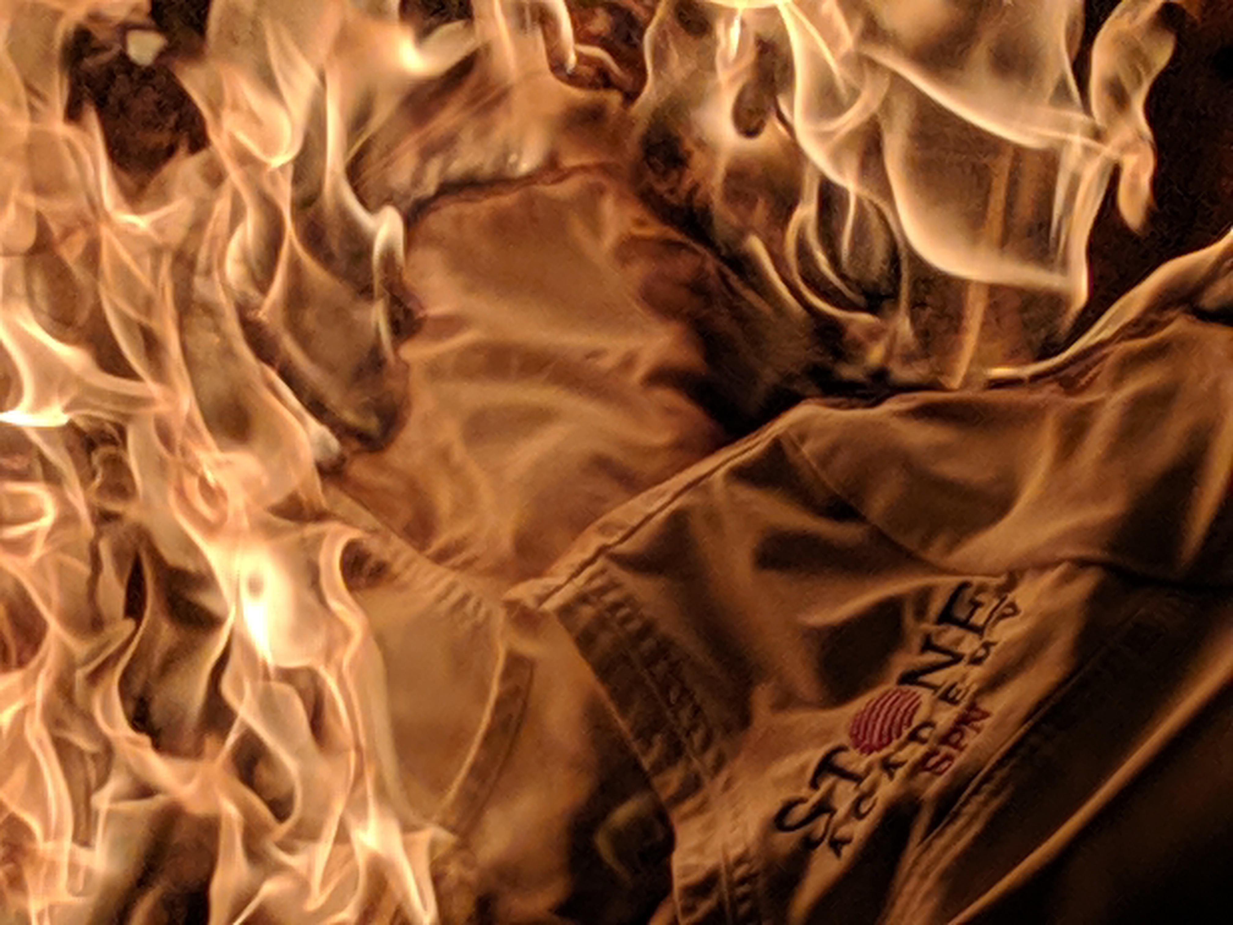 burning stone academy uniform on a pallete in a bon fire